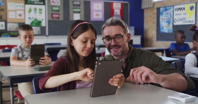 Male Teacher Assisting Student with Tablet in Classroom - Download Free Stock Images Pikwizard.com