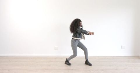 Stylish Woman Dancing Energetically in Minimalist Room