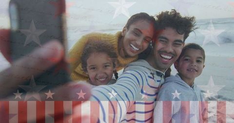 Happy Family Taking Selfie at Sunset Beach with Patriotic Overlay
