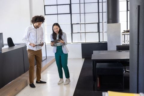 Diverse Team Collaborating on Tablets in Modern Office Setting