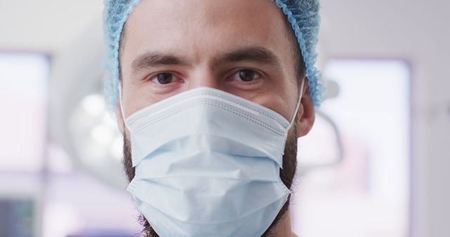 Close-up of surgeon with mask and surgical cap in operating room - Download Free Stock Images Pikwizard.com