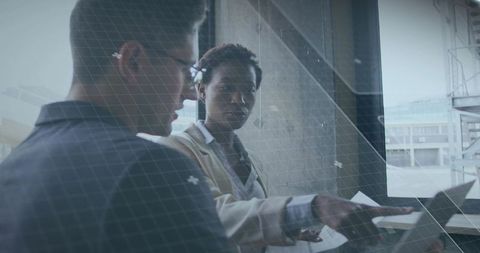 Collaborative Architectural Professionals Analyzing Plans at Site Window