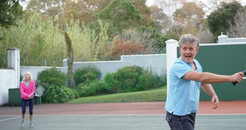 Senior Couple Enjoying Tennis Match on Open Court