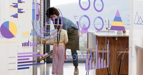 Caregiver guiding child opening lower kitchen cabinet while viewing ar data visualizations