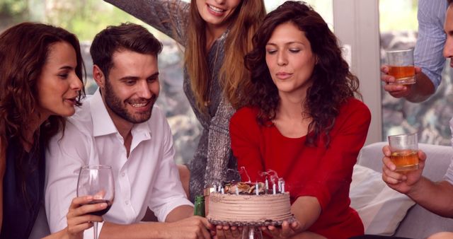 Woman blowing out candle on her birthday cake 