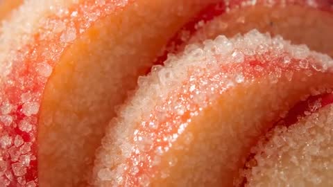 Shifting focus across macro frames revealing sugar crystals sparkling on sliced peach