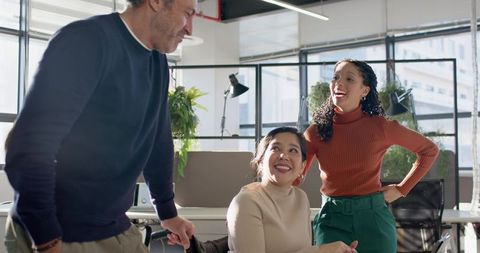 Diverse Team Collaborating in Bright Open-Plan Office, Smiling and Brainstorming