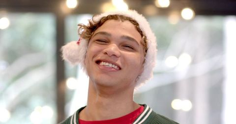 Joyful Young Man in Santa Hat Celebrating Holiday Season Indoors