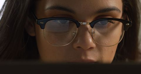 Focused young woman in glasses concentrating on digital screen