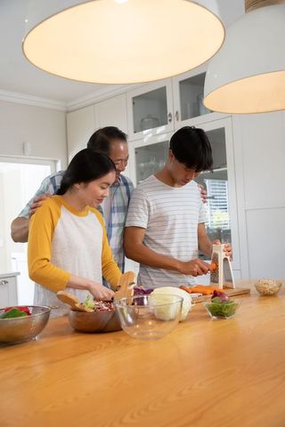 Asian Family Cooking Together in Modern Kitchen