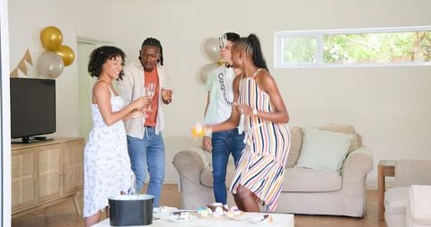 Friends Celebrating at Home with Drinks and Cake in Festive Environment
