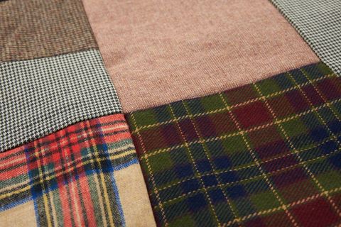Patchwork wool plaid and houndstooth textiles creating cozy rustic tartan fabric pattern