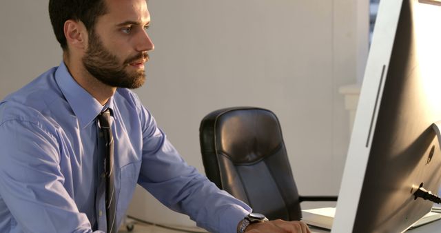 Focused Businessman Working on Desktop Computer in Office - Download Free Stock Images Pikwizard.com