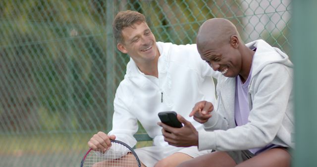 Two Friends Relaxing on Tennis Court Using Smartphone - Download Free Stock Images Pikwizard.com