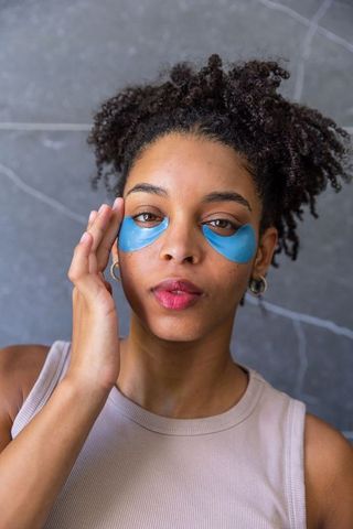 African american woman wearing blue hydrogel eye patches, skincare beauty headshot