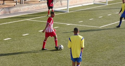 Youth Soccer Players Engaged in Intense Match on Grass Field