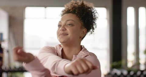 African american woman stretching arms in gym warming up for strength training