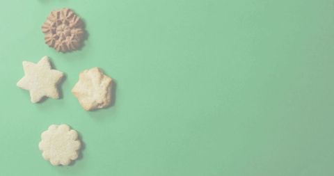 Flat lay assortment of shortbread cookies on mint green backdrop with copy space
