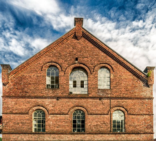 Historic Red Brick Building with Arched Windows and Blue Sky - Download Free Stock Images Pikwizard.com