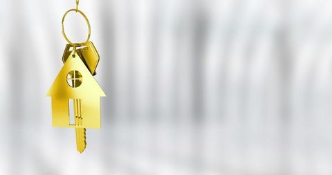 Hanging gold house keychain with round window and brass key on ring, minimalist real estate concept