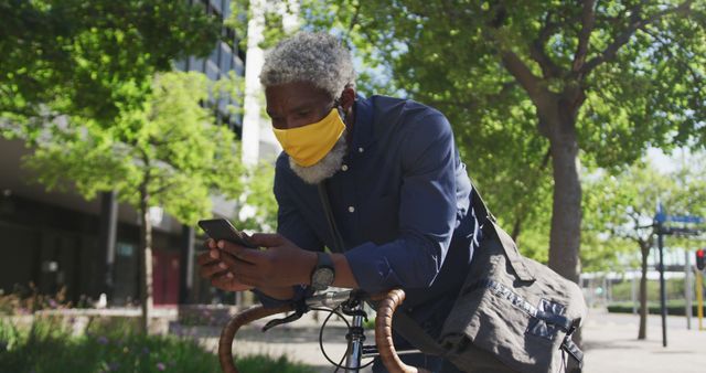 Senior Man in Face Mask Using Phone While Urban Biking - Download Free Stock Images Pikwizard.com