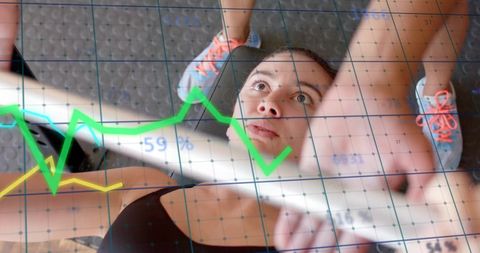 Caucasian Woman Lifting Weights with Digital Graph Overlay