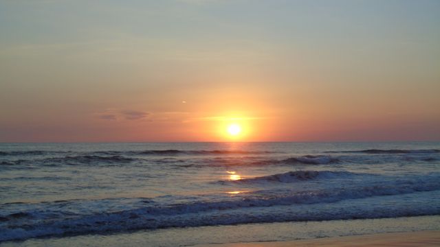 Serene Beach Sunset Over Tranquil Ocean Waves - Download Free Stock Photos Pikwizard.com
