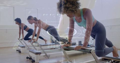Women Practicing Pilates on Reformers in Studio with Fitness Wear