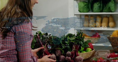 Woman lifting fresh beets at farmers market with global digital map overlay