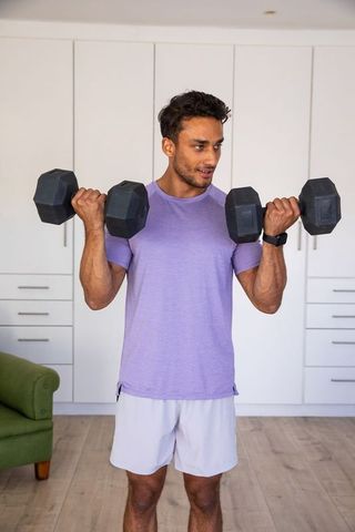 Man Exercising with Dumbbells in Home Gym Invokes Strength and Wellness