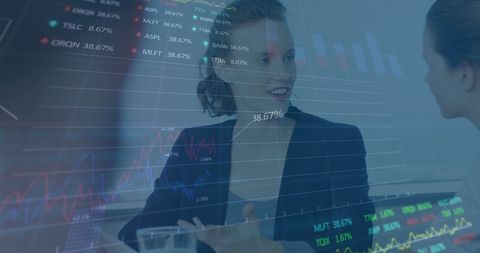 Businesswomen Discussing Financial Data Analysis Over Confidential Graphs