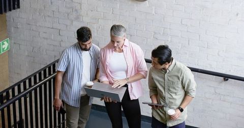 Diverse Team Collaborating on Landing Holding Tech Devices
