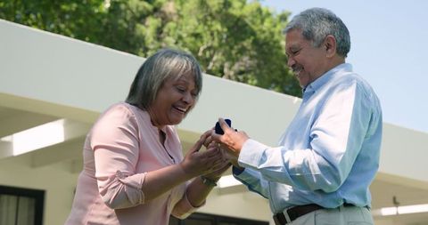 Senior couple engagement celebration on sunny day in yard