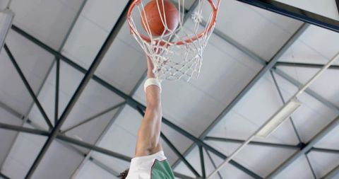 Basketball Player Dunking on Indoor Court Captured Mid-Action