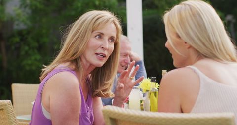 Happy caucasian senior mother and adult daughter talking at family dinner table in garden - Download Free Stock Photos Pikwizard.com