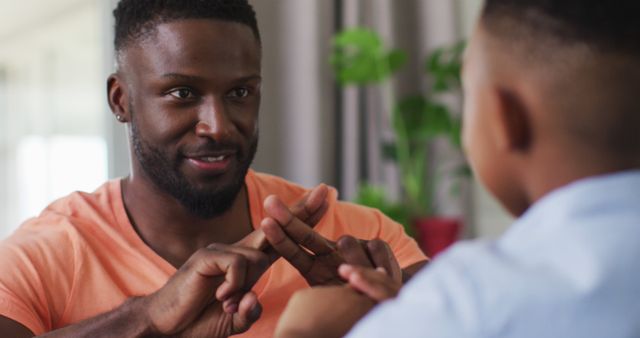 Smiling Father Teaching Sign Language to Young Son at Home - Download Free Stock Images Pikwizard.com