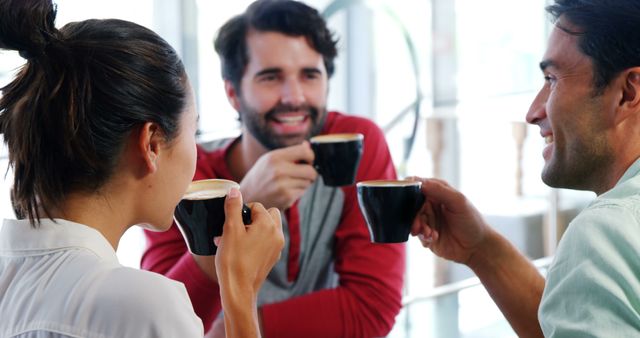 Group of friends enjoying coffee together in a modern café. Ideal for illustrating themes of friendship, leisure activities, socializing, casual meetings, and modern lifestyle.