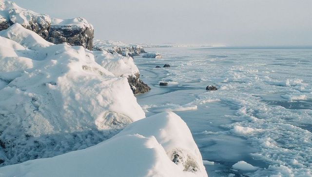 Snow covered coastline with icy sea in arctic winter