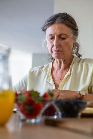 Senior Woman Preparing Berries for a Healthy Meal in Home Kitchen