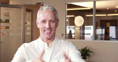 Middle-Aged Businessman Making Heart Gesture in Office