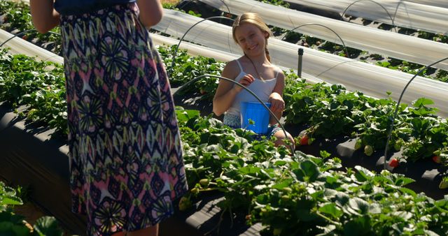 Teenage Caucasian girl enjoys picking strawberries outdoors - Download Free Stock Photos Pikwizard.com