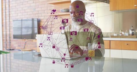 Senior Man Typing on Laptop Surrounded by Technology Icons at Home