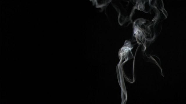 This image shows elegant swirls of incense smoke curling and twisting against a dark black background. The smoke trails create an aura of mystery and tranquility, making this ideal for themes related to meditation, spirituality, or relaxation. Its simplicity and serenity can be useful for websites or content focused on mindfulness, spiritual guidance, or abstract artistic expressions.