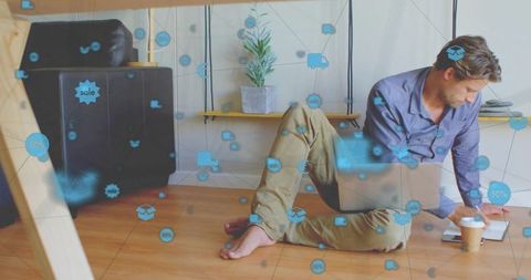 Freelancer working remotely on laptop at home floor workspace with ecommerce and cloud icons