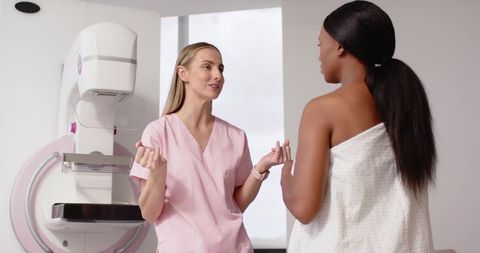 Mammography consult: technologist talking with Black patient before breast screening