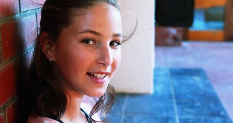 Smiling Schoolgirl Outdoors Relaxing by Brick Wall - Download Free Stock Images Pikwizard.com