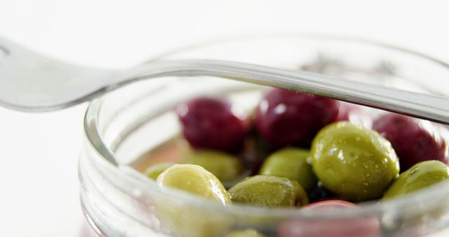 Close-Up of Mixed Green and Purple Olives in Glass Jar with Fork - Download Free Stock Images Pikwizard.com