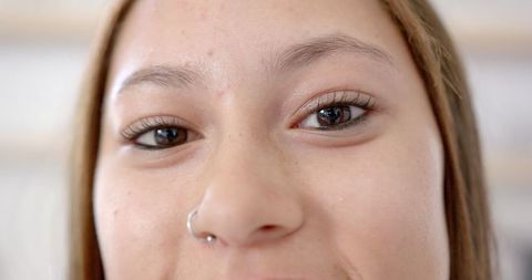 Close-Up Portrait of Smiling Young Woman with Nose Piercing