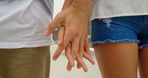 Close-Up of Couple Holding Hands on Beach