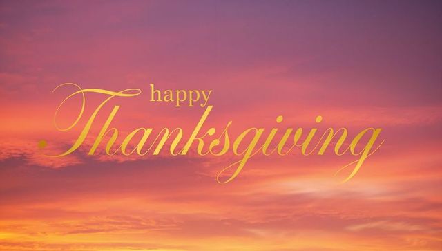 Golden happy thanksgiving calligraphy over vibrant sunset sky for holiday cards